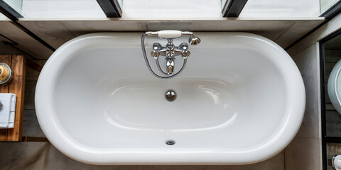 Overhead View of a Clean White Freestanding Bathtub with Chrome Faucet in a Modern Bathroom
