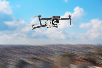 Drone with camera flying over city, motion blur effect. Unmanned aerial vehicle for surveillance