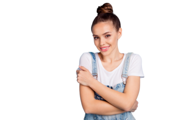 Portrait of charming youth cuddling herself wearing white t-shirt denim jeans overall isolated over blue background