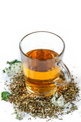 Herbal tea served in a glass cup with dried herbs