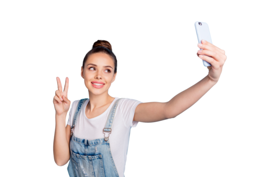 Photo of cheerful beautiful attractive nice girl showing you v-sign wearing jeans denim overall while isolated with blue background