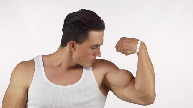 Muscular young man flexing his bicep with fierce determination