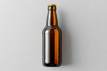 Fototapeta premium A brown glass beer bottle with a yellow cap is placed upright on a plain, light-colored background.