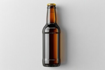 Fototapeta premium Brown glass beer bottle with a gold cap on a light background, viewed from above.