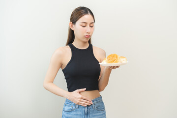 Gluten allergy, asian young woman hand holding, refusing to eat white loaf slice on plate in...