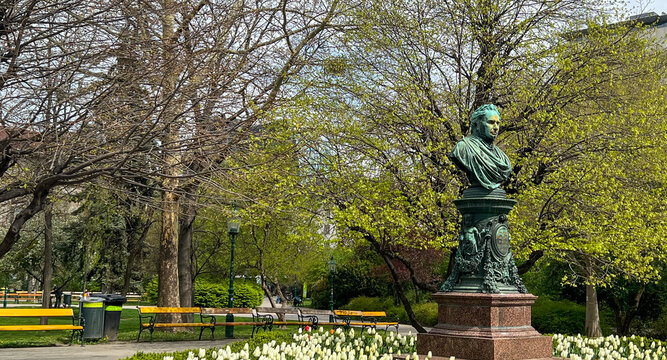 Bronze Bust of Andreas Zelinka surrounded by flower bed, trees and benches in Vienna&rsquo;s Stadtpark. Monument to Former Vienna Mayor Zelinka from 1861 to 1868. Vienna Austria, April 2025.