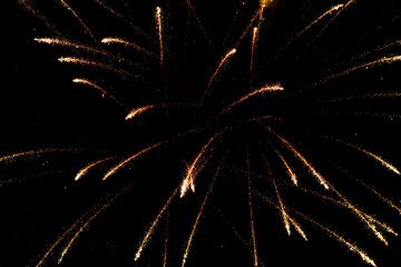 Spectacular golden fireworks show in night sky, shining sparks and trails perfect for celebration and backgrounds