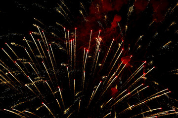 Spectacular golden fireworks show in night sky, shining sparks and trails perfect for celebration and backgrounds