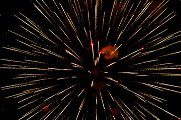Spectacular golden fireworks show in night sky, shining sparks and trails perfect for celebration and backgrounds