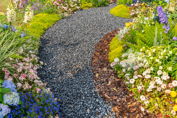 Walkway in flower garden in summer time. Colourful Flowerbeds in a good care maintenance landscapes and walkway
