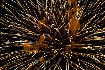 Spectacular golden fireworks show in night sky, shining sparks and trails perfect for celebration and backgrounds