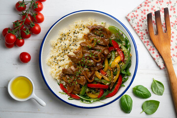 Dish with soy beef, peppers, and rice. Top view table.