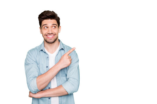 Photo of amazing salesman guy in excited mood indicating finger to empty space advising cool shopping prices wear casual denim shirt isolated green color background