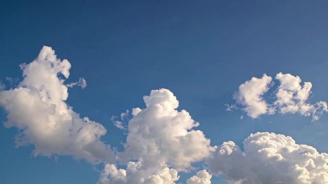 Fluffy white clouds rolling across a clear blue sky