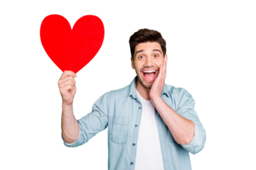 Photo of amazing guy holding big red paper heart open mouth overjoyed with cool creative prom invitation wear denim shirt isolated green color background