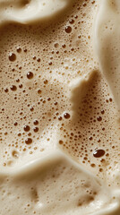 Creamy cappuccino foam with swirling patterns and bubbles, a macro and full-frame texture shot, close-up texture, top view