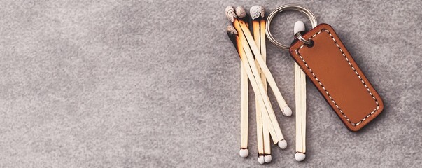 Burnt Matches and Leather Keychain on Grey,still life ,everyday objects