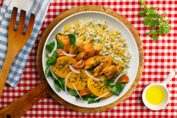 Combination plate with chicken, persimmon salad and rice. Top view table.