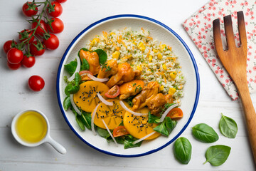 Combination plate with chicken, persimmon salad and rice. Top view table.