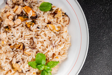 Rice seafood risotto mussels, shrimp, prawn, rapan, squid vegetable dish fresh gourmet food background on the table rustic food top view copy space