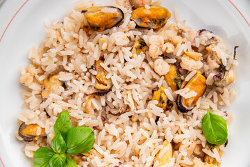 Rice seafood risotto mussels, shrimp, prawn, rapan, squid vegetable dish fresh gourmet food background on the table rustic food top view copy space