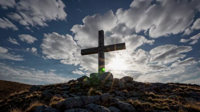Majestic mountain cross against vibrant sky with rolling clouds and sunlight