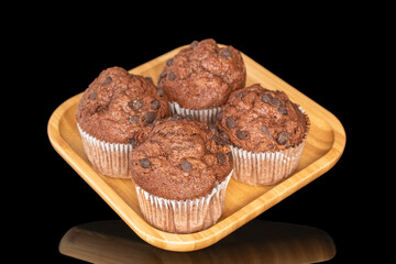 Chocolate muffins with chocolate pieces, close-up, isolated on black background.