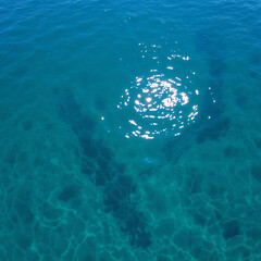 An aerial view of sunlight reflecting off the clear sea