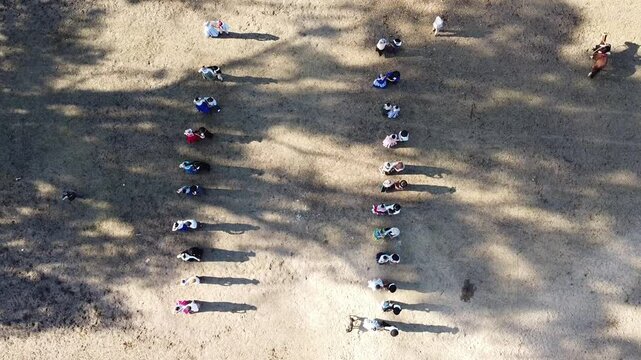 
Pairs of Argentine chacarera dancers dancing in a line and gaucho riders carrying flags at the Argentine national holiday.