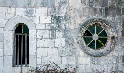 Old church round window in a stone wall. The circular window brick background.