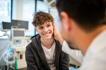 Teenage boy smiling during medical consultation after receiving positive health news.