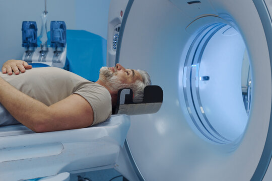 Male patient undergoing CT scan examination in hospital.