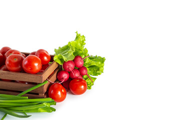Tomatoes, radishes, green onions and lettuce in a wooden box. Isolated on white background. Copy space.