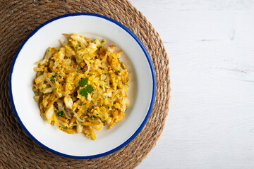 Cod o bras, golden cod with potatoes, a traditional Portuguese dish. Top view table.