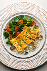 Dish with an omelet filled with cheese, rice and salad. Top view table.
