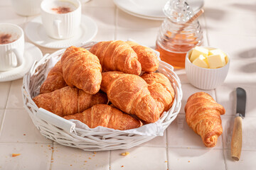 Crunchy and tasty french croissants with honey for breakfast.