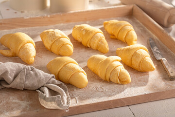 Sweet french croissants preparing from raw dough.