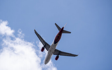 Bottom view of a commercial airplane taking off into the cloudy sky from Soekarno-Hatta International Airport, Jakarta.
