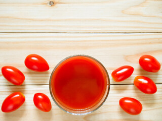 A glass of tomato juice on wooden table