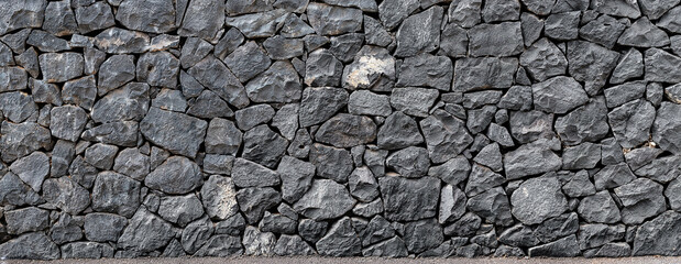Panoramic texture of a natural volcanic stone wall from Tenerife, Spain