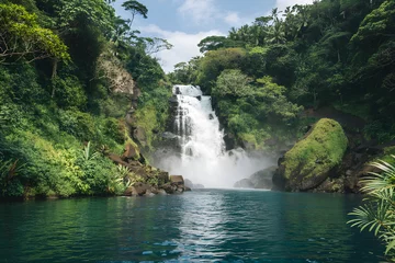 Fototapete Majestic waterfall cascading into tranquil turquoise pool in lush tropical rainforest © Gatherina