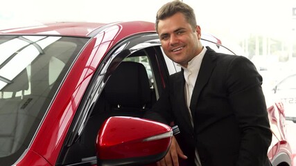 Cheerful salesman enthusiastically showcases the car's quality with a thumbs up