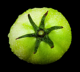 Green tomato isolated on black background.