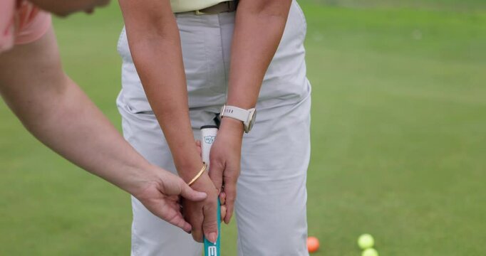 Woman, coach and sport training for golf on course for development in stroke or swing of club. Hands, closeup and personal trainer help player with stick, hit and balls on pitch in sports game