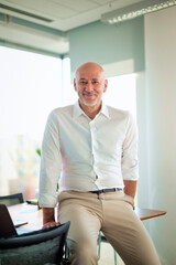 Confident businessman standing at his desk in the office