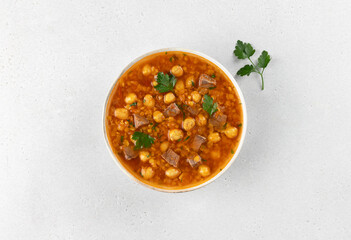 Moroccan harira soup with chickpeas, beef and spices on white background. Top view. Arabic food.