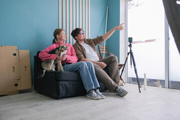 a couple toning windows glass at home using toning film, sitting on the sofa looking at the job