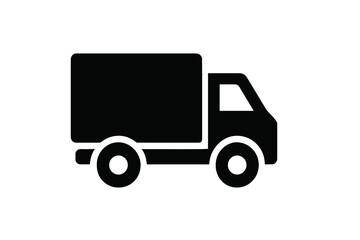 Fototapeta premium Delivery truck moving along a city street during daylight hours in an urban setting with buildings in the background