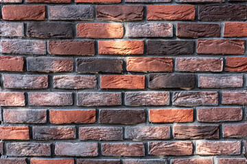 Textured brick wall with a mix of red and brown tones in urban setting