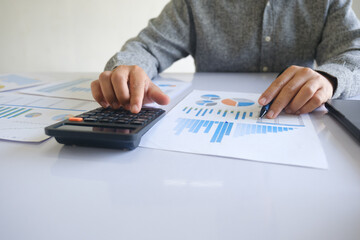 Close up accountant banker or bookkeeper making calculations with calculator.